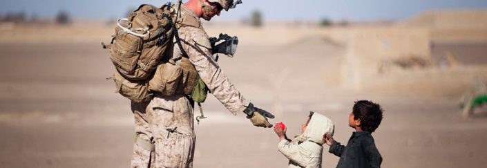 Small child giving soldier a ball Small child giving soldier a ball