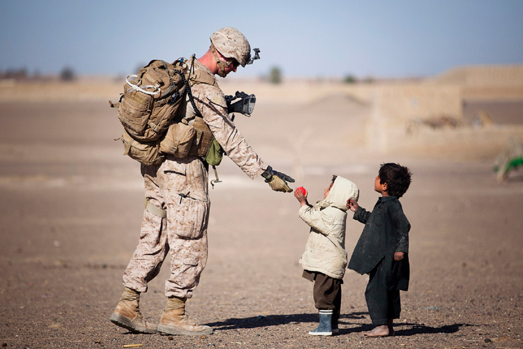 Small child giving soldier a ball Small child giving soldier a ball